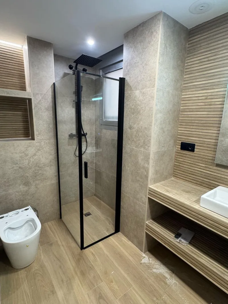 Mampara de ducha con perfil negro instalada en un baño